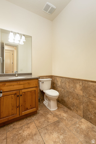 888 East Fiddlers Canyon Road Cedar City, UT 84721 - Photo 27 of 74 Bathroom with vanity, wainscoting, and tile walls