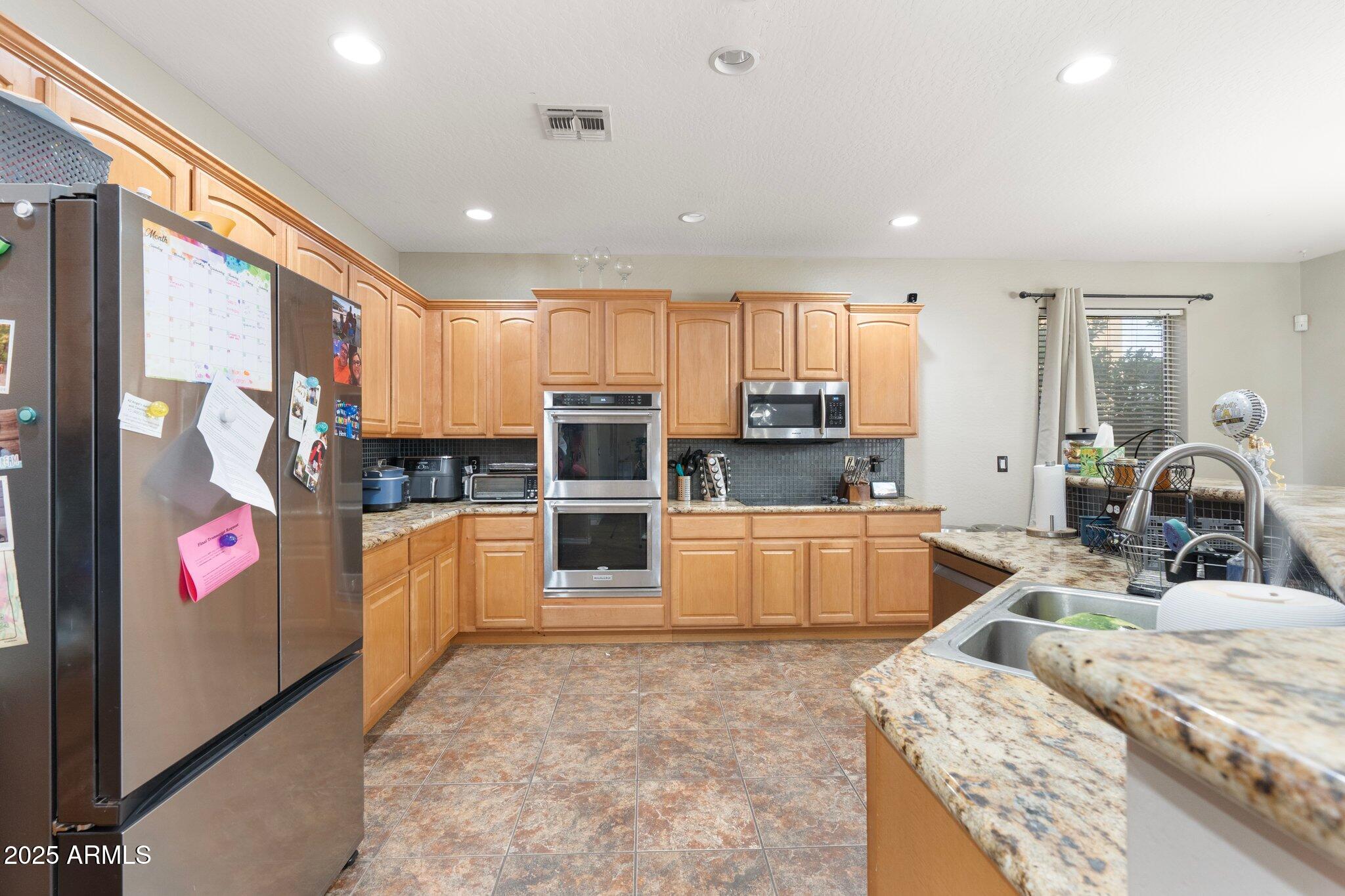 6202 West Maya Drive Phoenix, AZ 85083 - Photo 14 of 43 a kitchen with stainless steel appliances kitchen island granite countertop a stove and cabinets