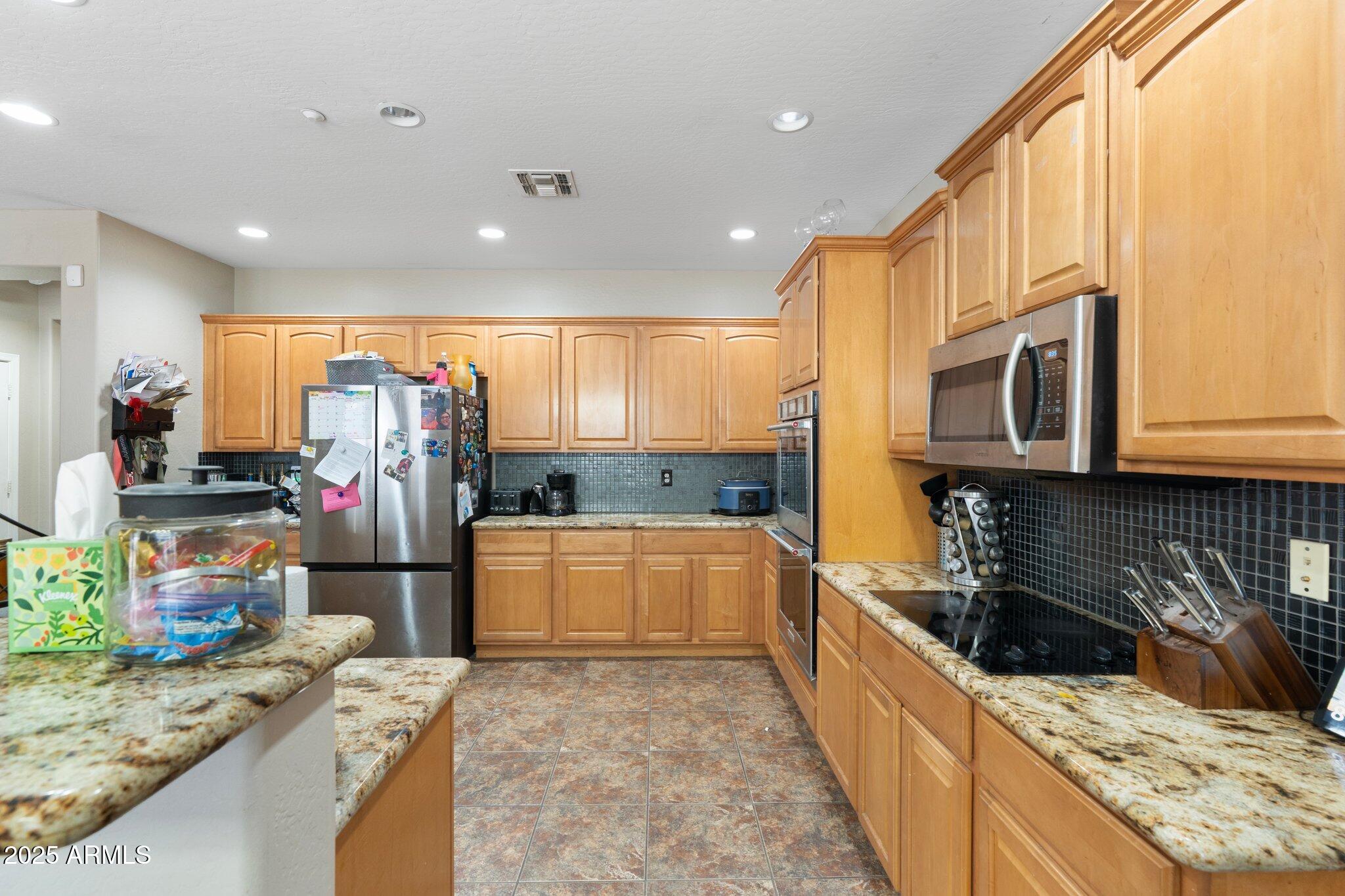 6202 West Maya Drive Phoenix, AZ 85083 - Photo 16 of 43 a kitchen with stainless steel appliances kitchen island granite countertop a refrigerator and a stove top oven