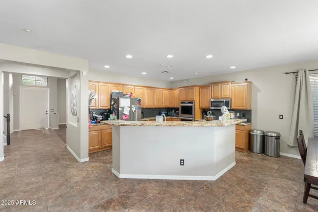 a view of kitchen with stainless steel appliances a refrigerator a sink dishwasher with a dining table and chairs