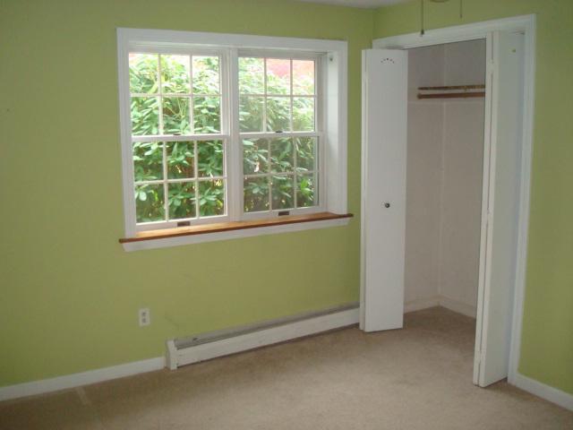 262 Jones Road Marstons Mills, MA 02648 - Photo 4 of 8 an empty room with a window and a kitchen