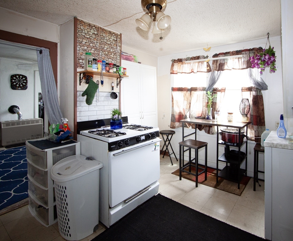 66 Cutler Street Worcester, MA 01604 - Photo 22 of 27 a kitchen with a stove and white cabinets