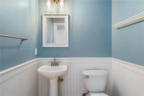 a bathroom with a toilet a sink and mirror