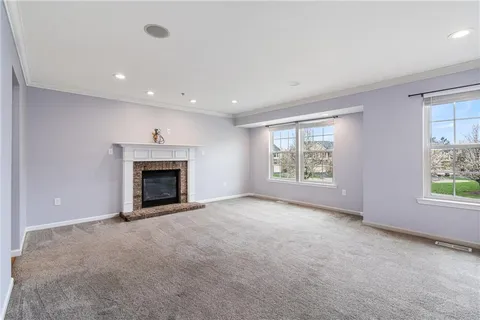 an empty room with windows and fireplace
