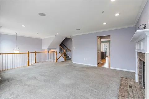 a view of an empty room with stairs and a window