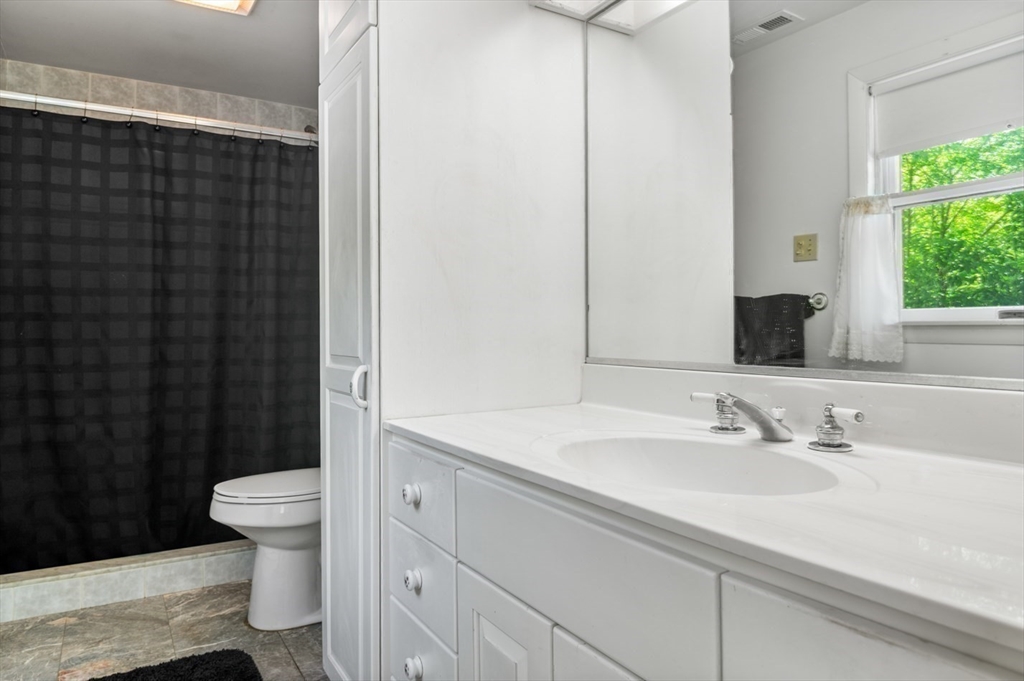 7 Bray Street Gloucester, MA 01930 - Photo 15 of 26 a bathroom with a sink a toilet a mirror and shower curtain