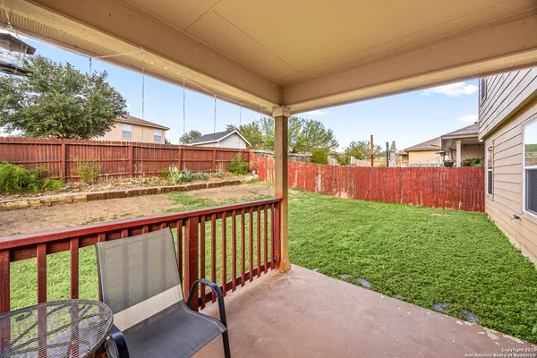 a view of a patio with a table chairs and a backyard