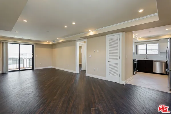a view of a big room with wooden floor and windows