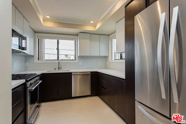 a kitchen with stainless steel appliances granite countertop a refrigerator and a sink
