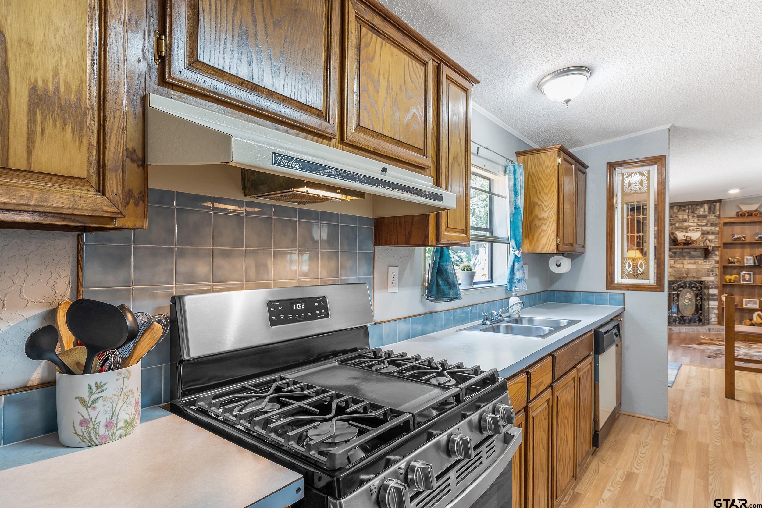 110 Sycamore Lane Murchison, TX 75778 - Photo 15 of 47 a kitchen with a stove and a wooden floor