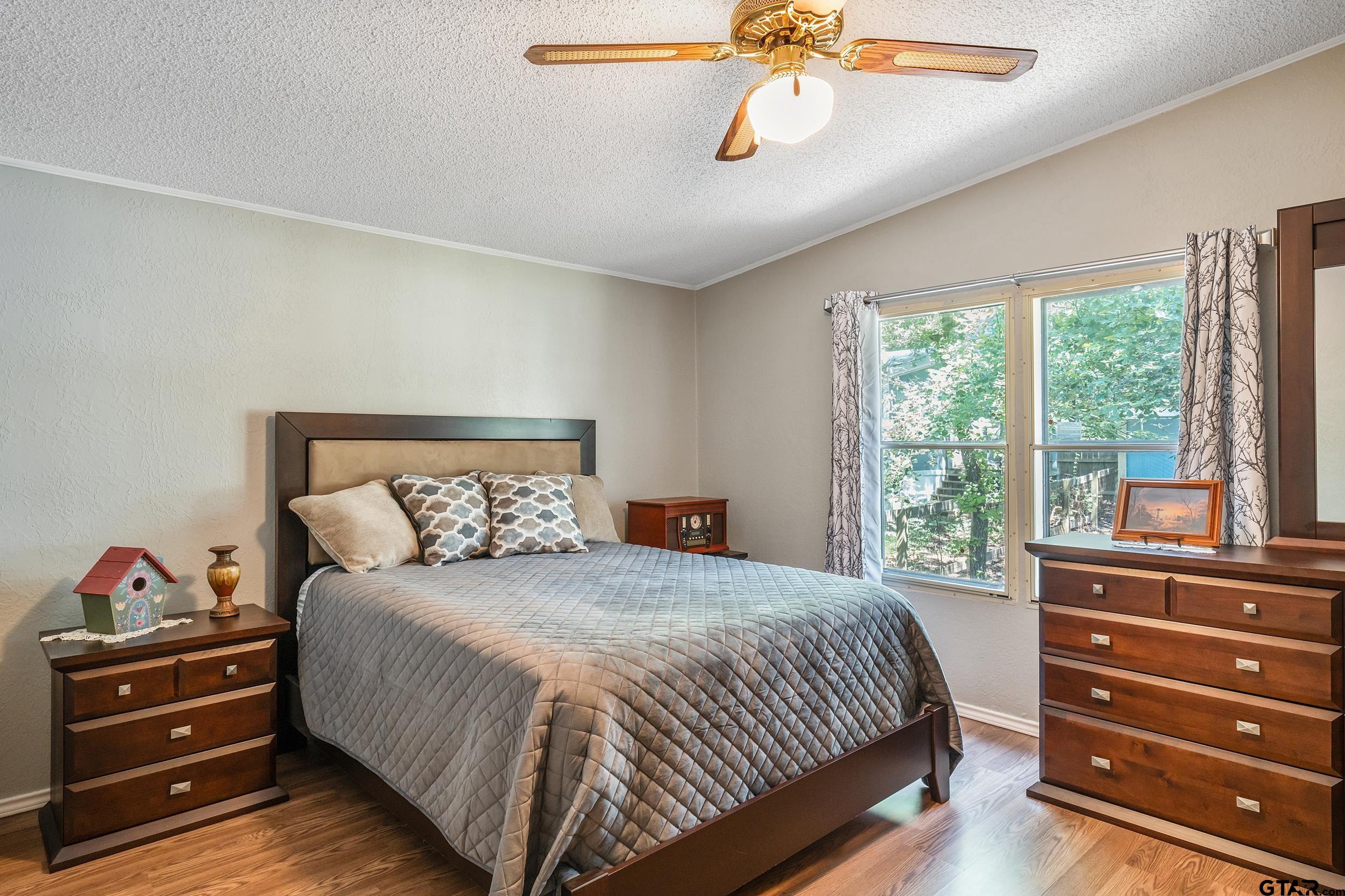 110 Sycamore Lane Murchison, TX 75778 - Photo 19 of 47 a bedroom with a bed and a chandelier
