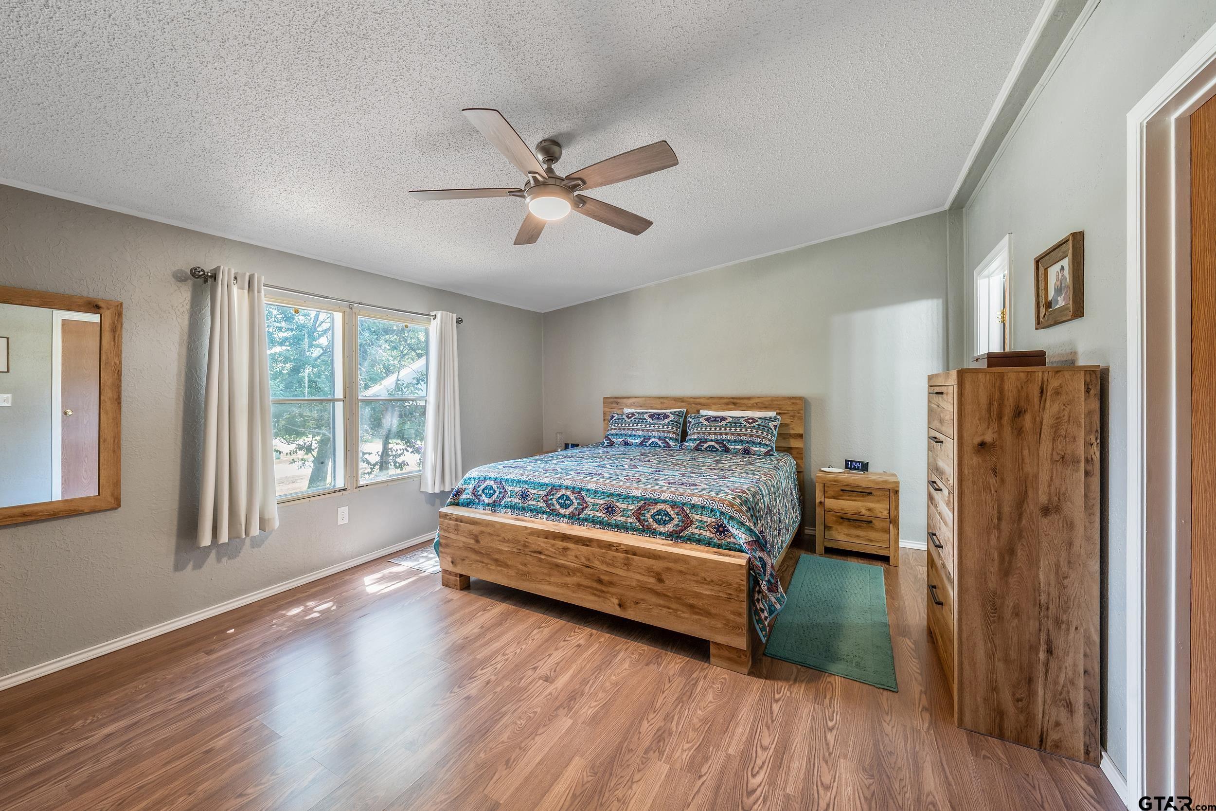 110 Sycamore Lane Murchison, TX 75778 - Photo 23 of 47 a bedroom with a bed closet and wooden floor