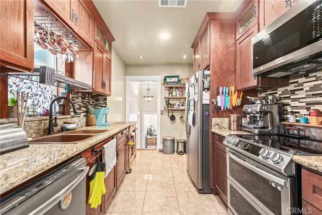a kitchen with stainless steel appliances granite countertop a sink stove and refrigerator
