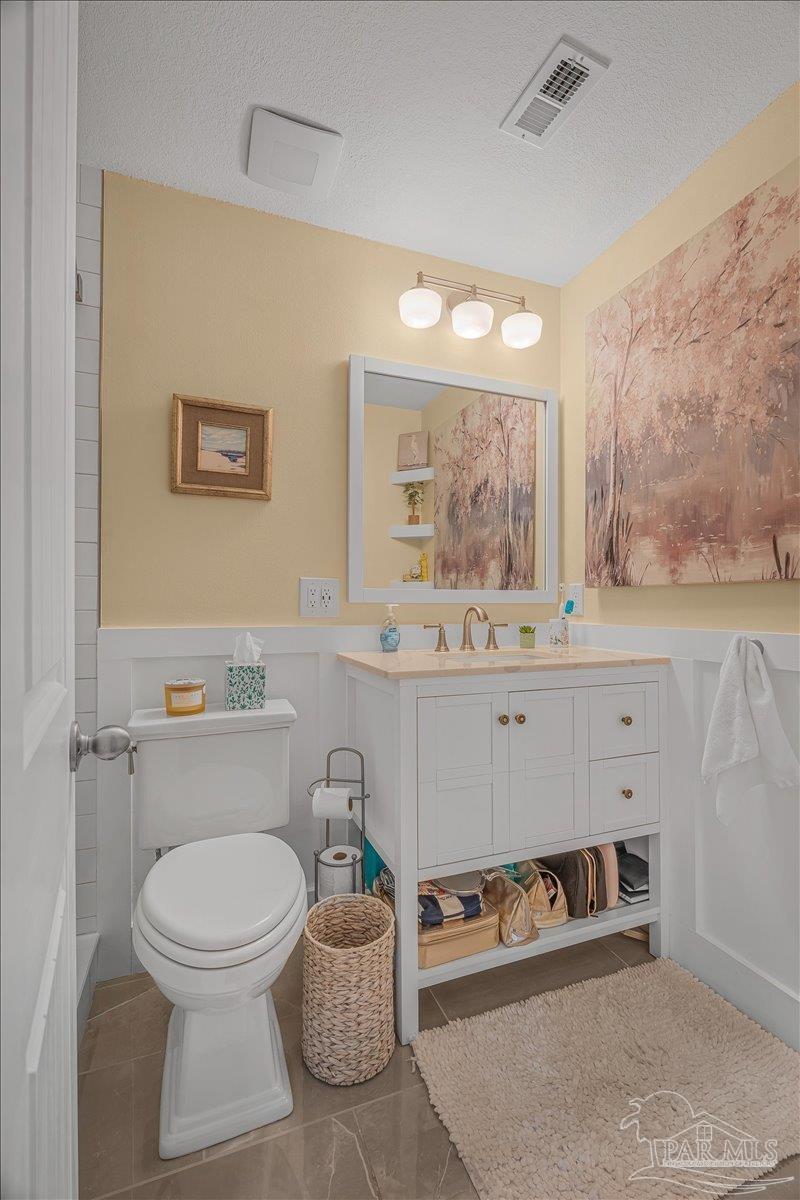 4831 East Olive Road, Unit 1D Pensacola, FL 32514 - Photo 17 of 36 a bathroom with a toilet sink and mirror