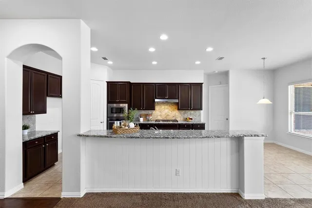 a kitchen with stainless steel appliances granite countertop a sink and a stove