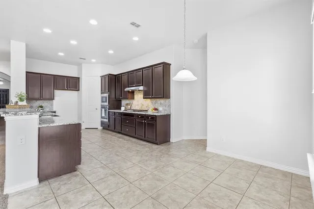 a kitchen with stainless steel appliances a refrigerator and a stove top oven