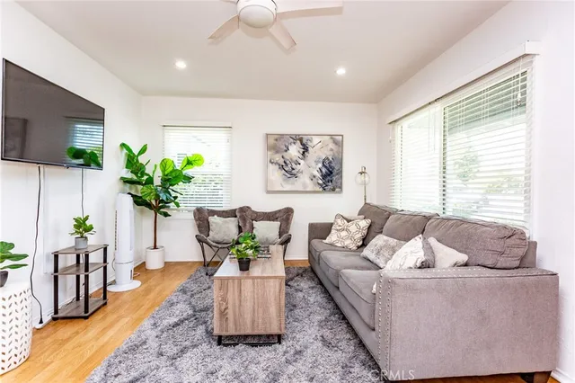 a living room with furniture potted plant and a flat screen tv