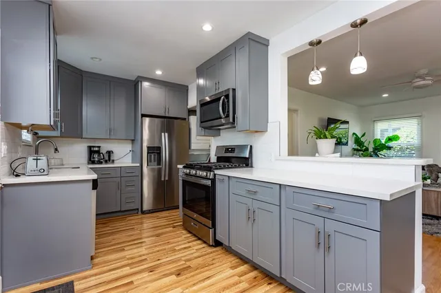 a kitchen with kitchen island granite countertop stainless steel appliances and sink