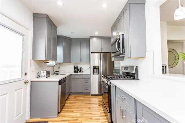 a kitchen with stainless steel appliances a sink stove refrigerator and cabinets