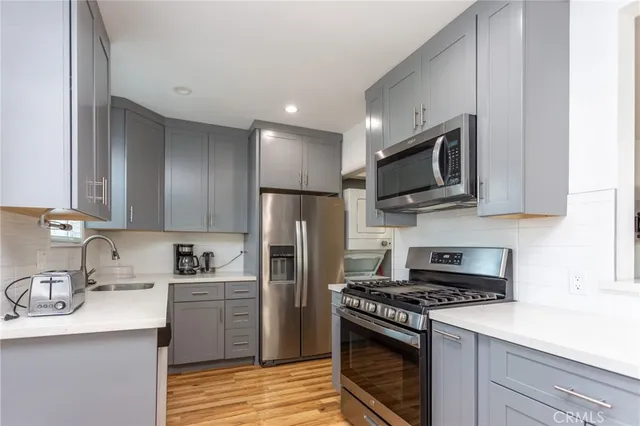 a kitchen with stainless steel appliances granite countertop a sink stove microwave and refrigerator