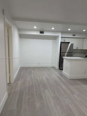 a view of a kitchen with a sink and a refrigerator