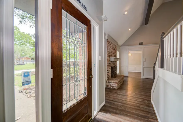 a view of a hallway view with living room and wooden floor
