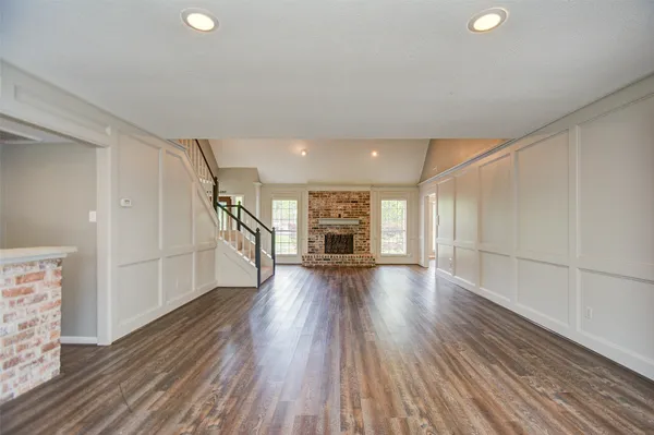 a view of empty room with wooden floor and fireplace