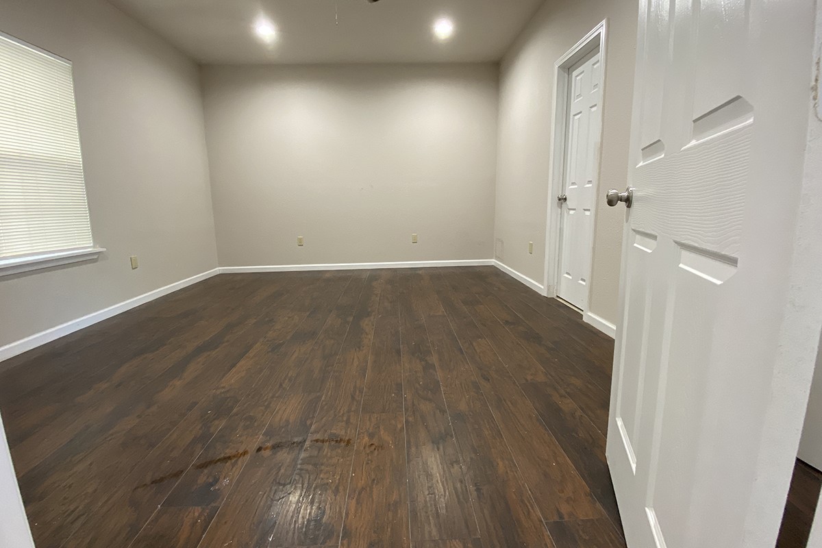 4601 Keystone Street Houston, TX 77021 - Photo 6 of 9 an empty room with wooden floor and windows