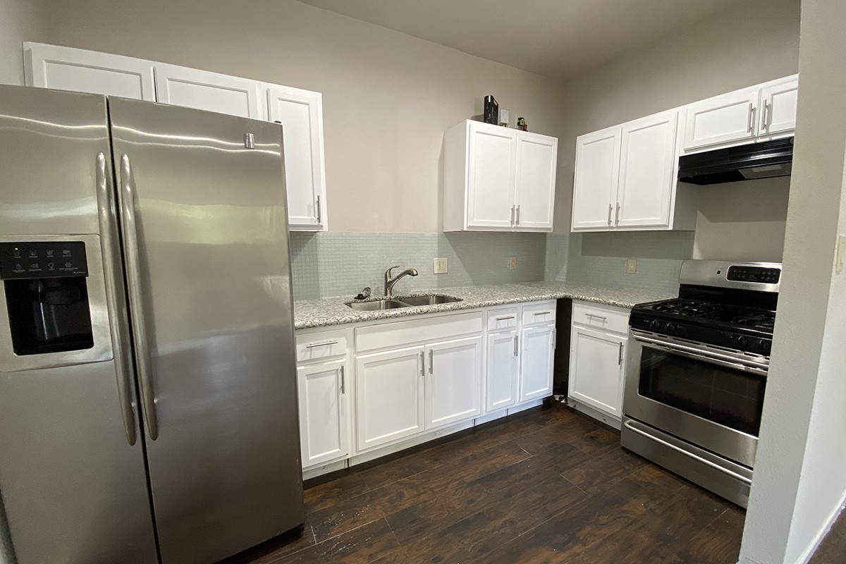4601 Keystone Street Houston, TX 77021 - Photo 8 of 9 a kitchen with a refrigerator stove and white cabinets