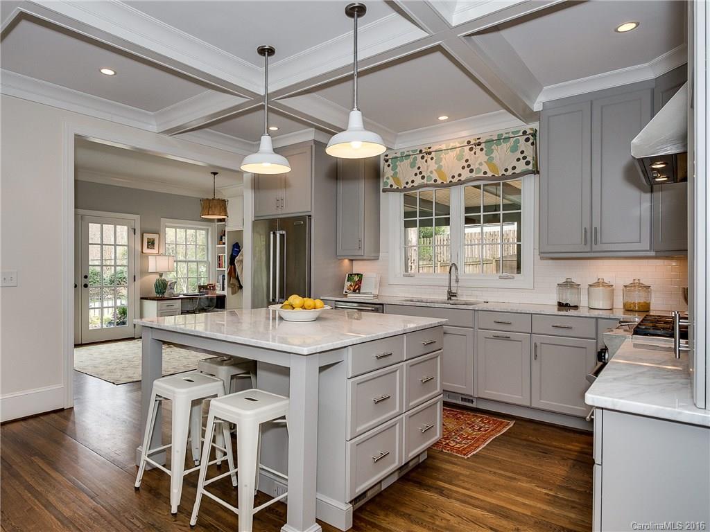 1418 Audubon Road Charlotte, NC 28211 - Photo 7 of 24 a kitchen with a stove a sink dishwasher a kitchen island with wooden cabinets and floor