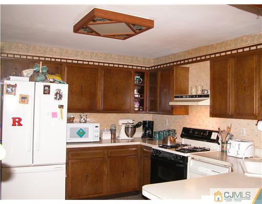 22 Harding Avenue Edison, NJ 08820 - Photo 8 of 14 a kitchen with stainless steel appliances a stove a sink and cabinets