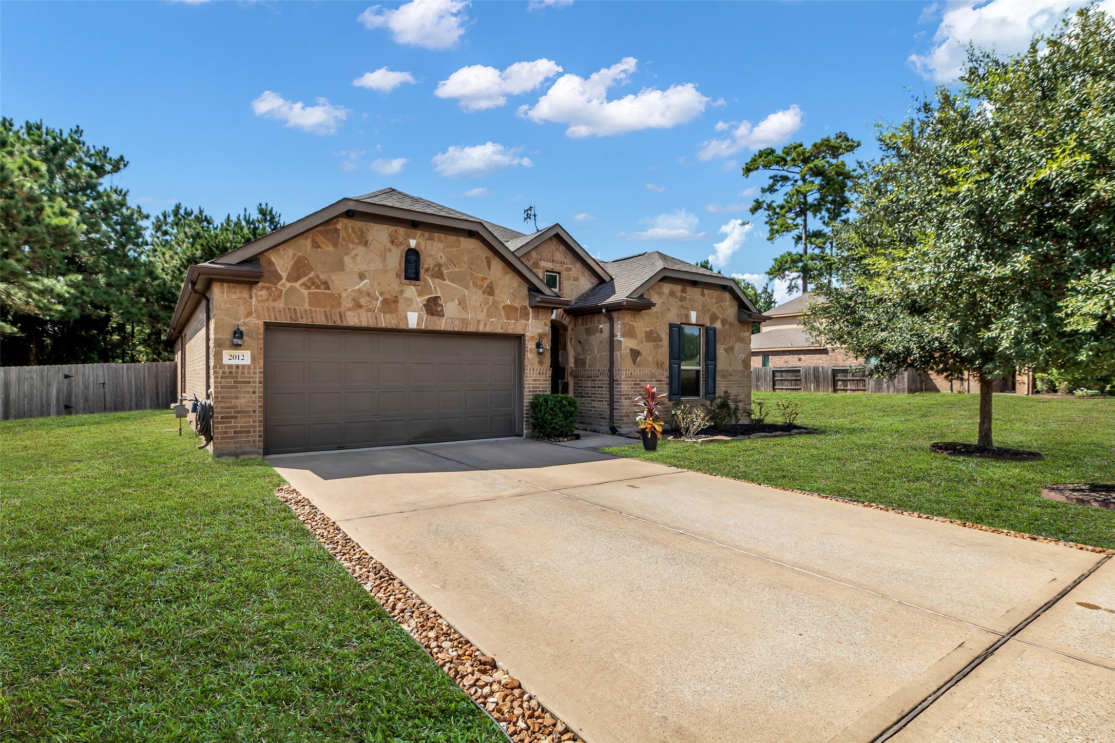 2012 Elkington Circle Conroe, TX 77304 - Photo 2 of 36 a front view of a house with a yard and garage