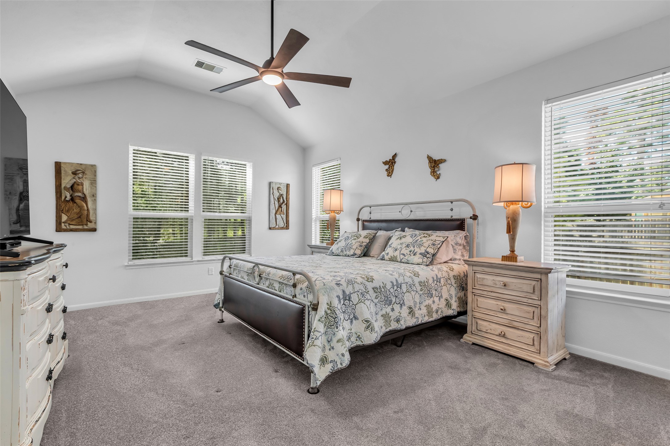 2012 Elkington Circle Conroe, TX 77304 - Photo 23 of 36 a spacious bedroom with a bed a dresser next to a window