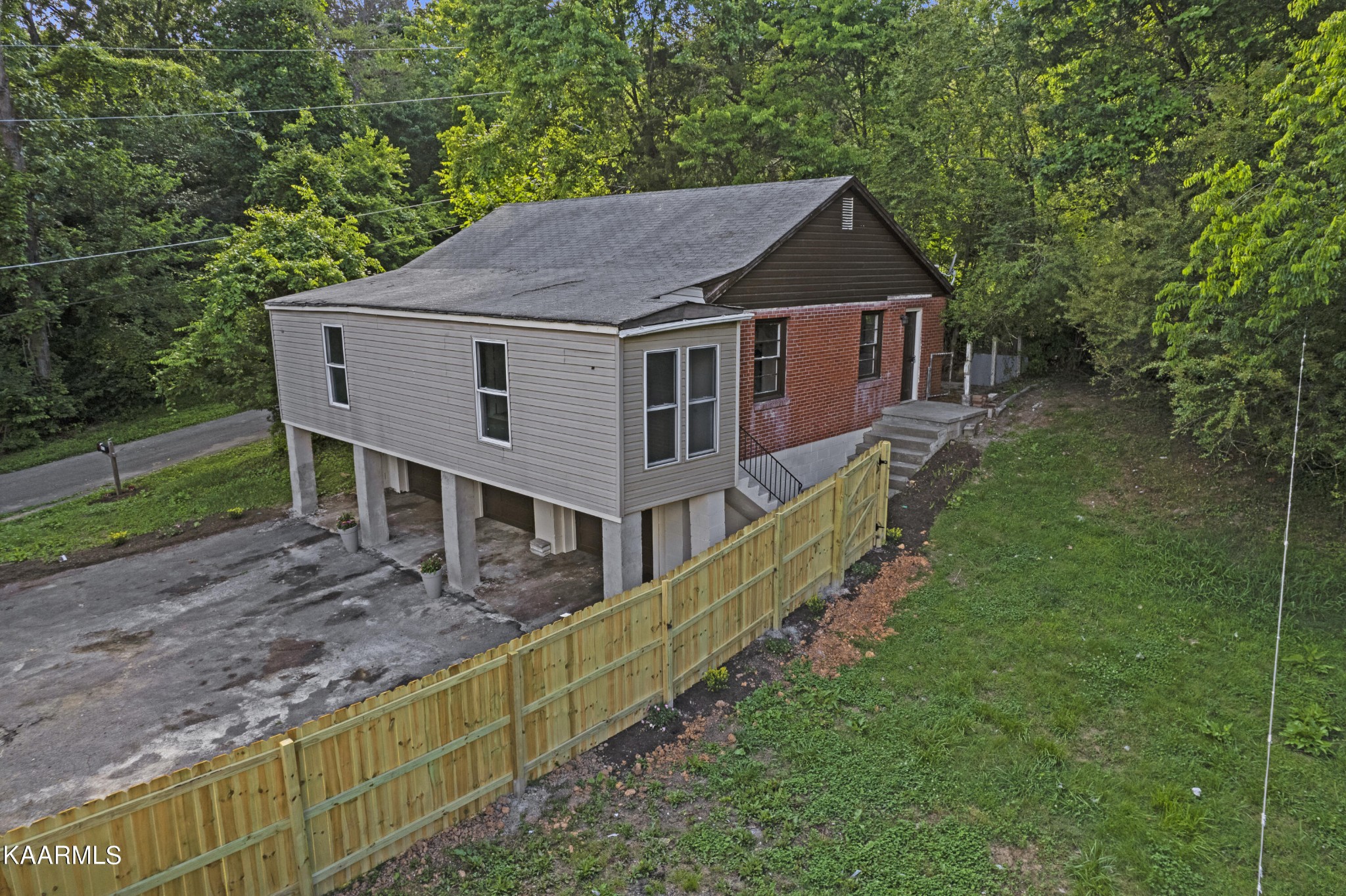 313 Potter Road Clinton, TN 37716 - Photo 17 of 24 a aerial view of a house next to a yard with plants and large trees