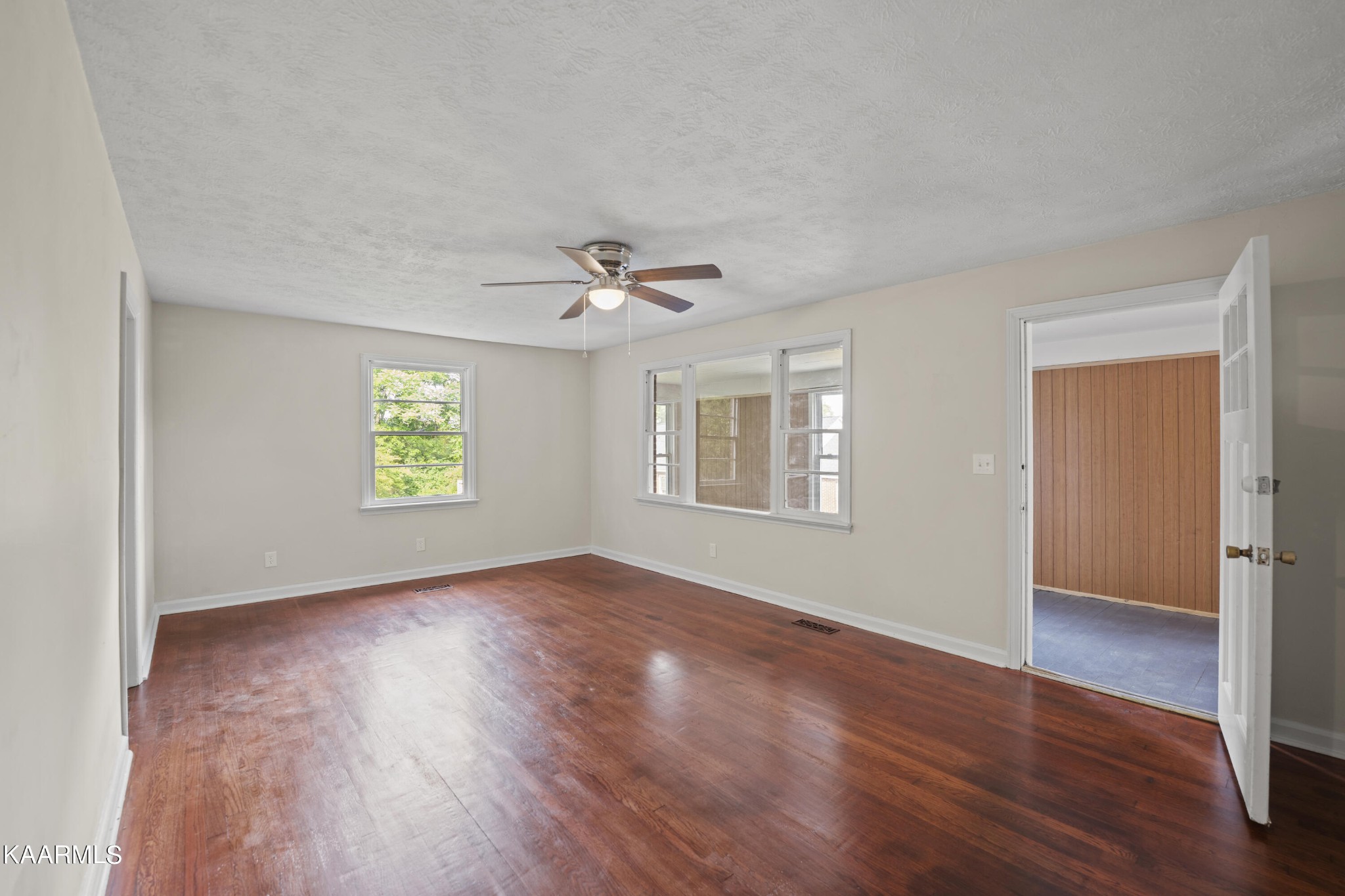 313 Potter Road Clinton, TN 37716 - Photo 4 of 24 an empty room with wooden floor chandelier and windows