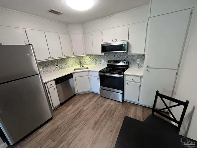 a kitchen with stainless steel appliances a white refrigerator sink and stove