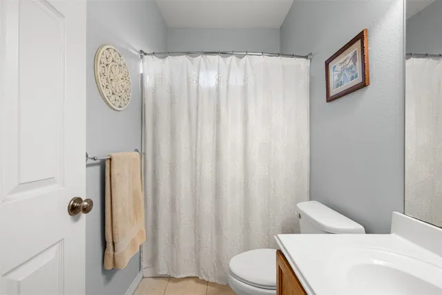 a white toilet sitting next to a shower curtain