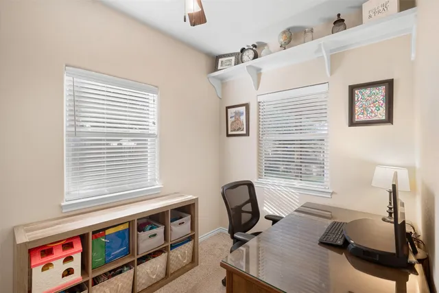 a view of a workspace with furniture and a window