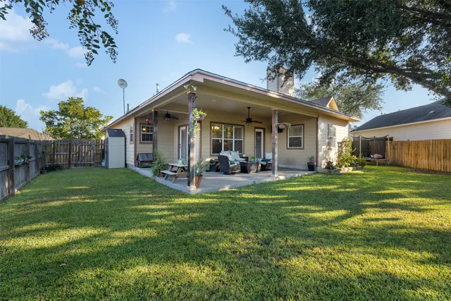 a view of a house with a big yard plants and large trees
