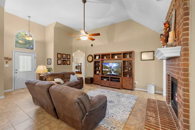a living room with furniture a fireplace and a flat screen tv