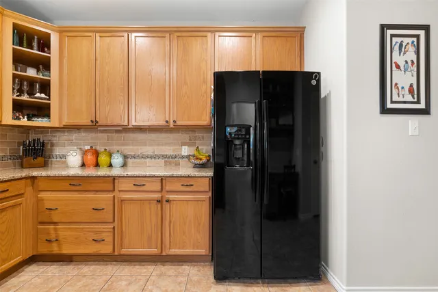 a kitchen with stainless steel appliances granite countertop a refrigerator and a stove top oven