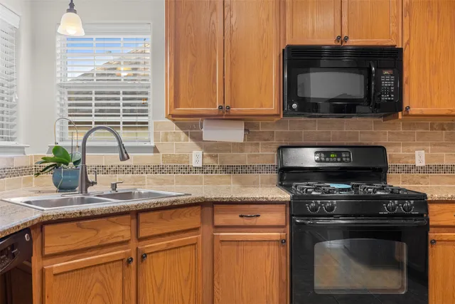 a kitchen with stainless steel appliances granite countertop white cabinets and a stove top oven