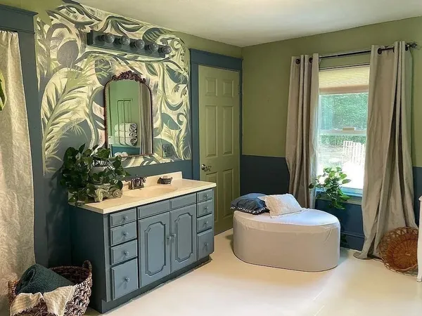 a bathroom with a sink and mirror with bathtub