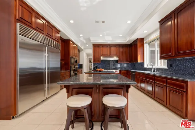 a living room with furniture a flat screen tv and kitchen view