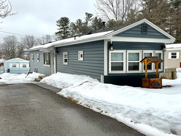a view of a house with a yard covered in snow