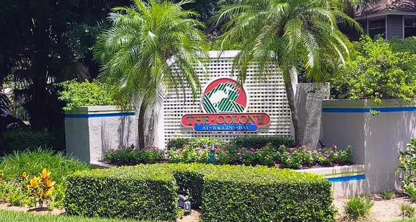 a sign that is on a brick wall with a plants