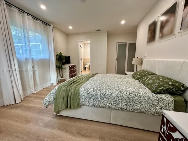 a bedroom with a large bed and a window