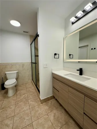 a bathroom with a sink a toilet and a mirror