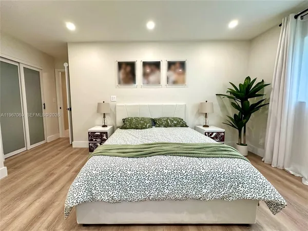 a bedroom with a large bed and a potted plant