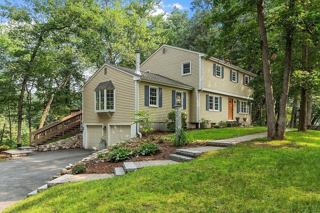a front view of a house with a yard and trees